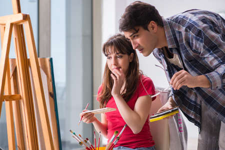 Artist coaching student in painting class in studioの写真素材