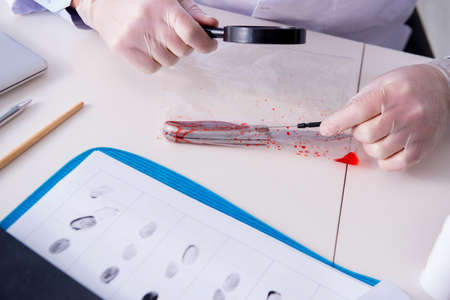 Criminologist police chemist looking at crime evidenceの写真素材