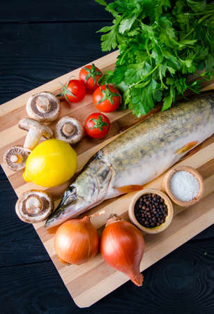 Uncooked fish on cutting board in meal preparation conceptの写真素材