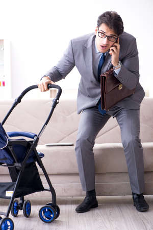 Businessman looking after newborn baby at home and teleworking