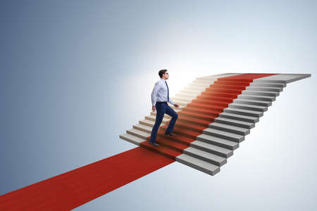 Young businessman climbing stairs and red carpet