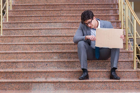 Desperate businessman begging on the streetの写真素材