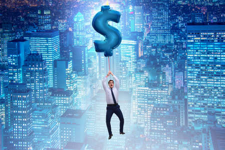 Businessman flying on dollar sign inflatable balloonの写真素材