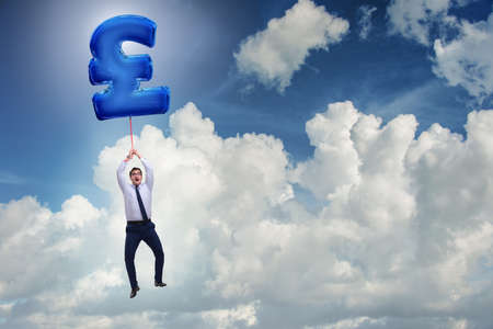 Businessman flying on british pound sign inflatable balloonの写真素材