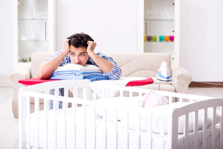 Young dad looking after newborn babyの写真素材