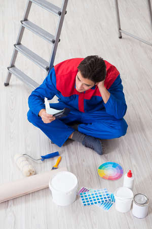 Young painter trying to match colours for painting jobの写真素材