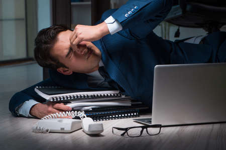 Businessman working overtime long hours late in officeの写真素材