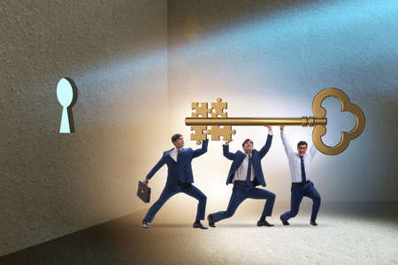 Businessmen with key having jigsaw puzzle elementsの写真素材