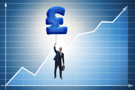 Businessman flying on british pound sign inflatable balloonの写真素材