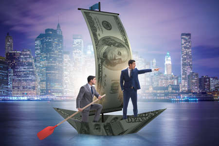 Business partnership with businessmen sailing on dollar boatの写真素材