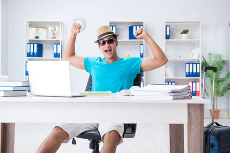 Businessman preparing for vacation in the officeの写真素材