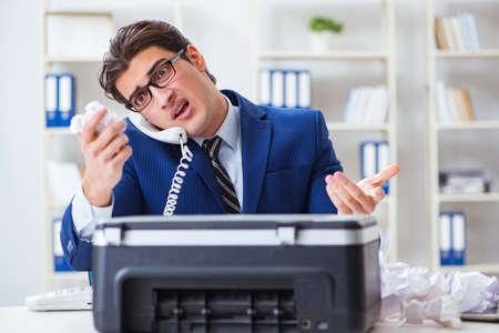 Businessman angry at copying machine jamming papers