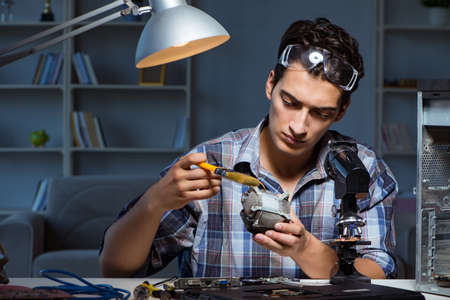 Computer repair man cleaning dust with brush