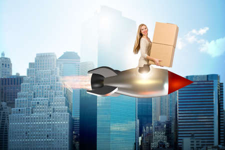 Woman in fast box delivery service on rocketの写真素材