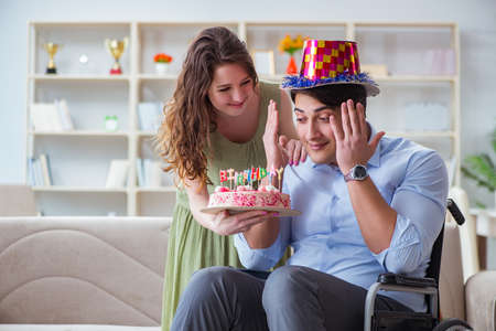 Young family celebrating birthday with disabled personの写真素材