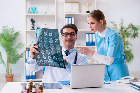 Two doctors examining x-ray images of patient for diagnosis