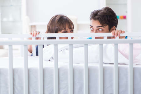 Happy young family at baby bed cotの写真素材