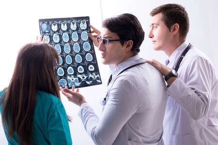 Three doctors discussing scan results of x-ray image