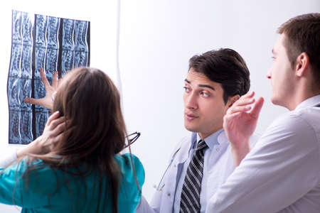Three doctors discussing scan results of x-ray image