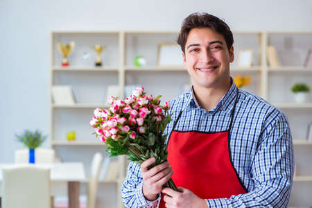 Flower shop assistant offering a bunch of flowersの写真素材
