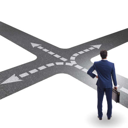 Young businessman at crossroads in uncertainty conceptの写真素材