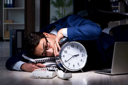 Businessman working overtime long hours late in officeの写真素材