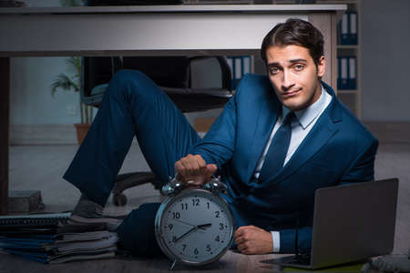Businessman working overtime long hours late in officeの写真素材