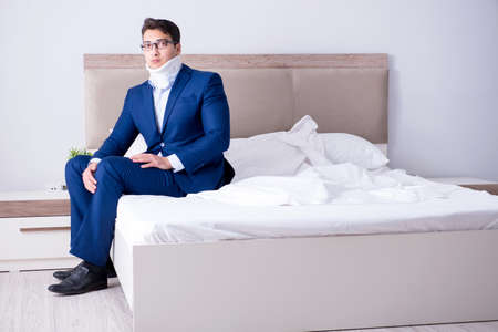 Businessman with neck injury working from homeの写真素材