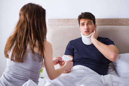Loving wife taking care of injured husband in bedの写真素材