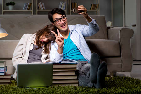 Two students studying late preparing for examsの写真素材