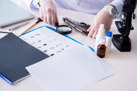 Criminologist police chemist looking at crime evidenceの写真素材