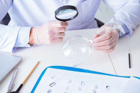 Criminologist police chemist looking at crime evidenceの写真素材