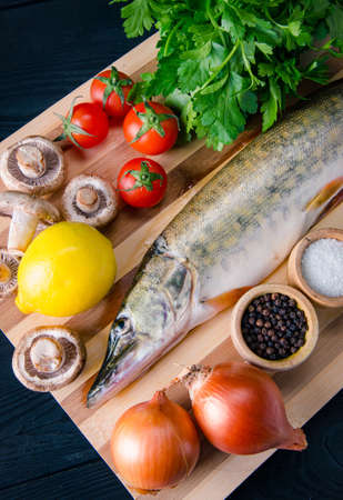 Uncooked fish on cutting board in meal preparation conceptの写真素材
