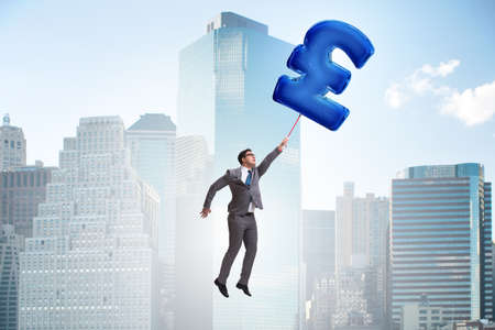 Businessman flying on british pound sign inflatable balloonの写真素材
