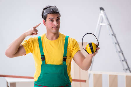 Worker showing the importance of wearing noise cancelling headphoneの写真素材