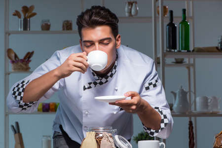 Coffee barista working late in shop preparing drinksの写真素材
