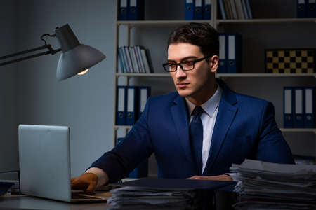 Businessman working late at night in office for overtime bonusの写真素材