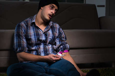 Young man in agony having problems with narcoticsの写真素材