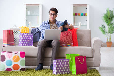 Young man buying clothing online and running blogの写真素材