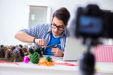 Young blogger recording video doing Christmas decorationの写真素材