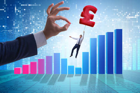 Businessman flying on british pound sign inflatable balloonの写真素材