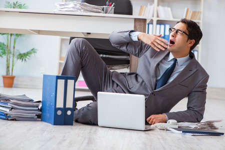 Businessman working and sitting on floor in officeの写真素材