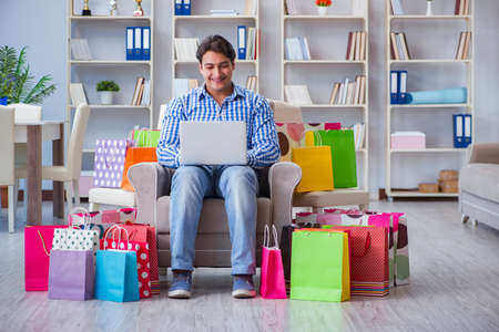 Young man after excessive shopping at homeの写真素材