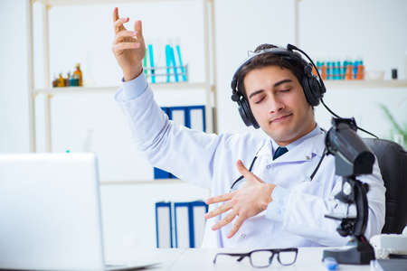 Happy excited doctor listening to music during lunch break in hospitalの写真素材