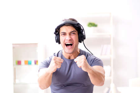 Man doing sports at home and listening to musicの写真素材