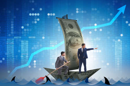 Businessman rowing on dollar boat in business financial conceptの写真素材