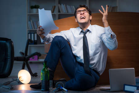 Stressed businessman working overtime in depressionの写真素材