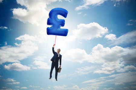 Businessman flying on british pound sign inflatable balloonの写真素材