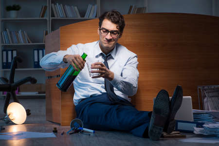 Stressed businessman working overtime in depressionの写真素材