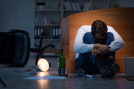 Stressed businessman working overtime in depressionの写真素材